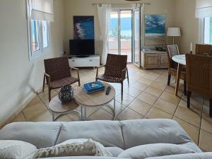a living room with a couch and chairs and a table at Sea View Villa Irene - Private Pool and Sunset Terrace in Evretí