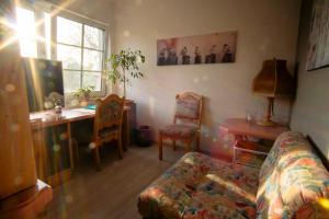 a living room with a couch and a desk at Pension An der Bleiche in Wustrau +10 photos