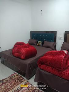 a bedroom with two beds with red pillows on them at Hotel Mahadev in Sonprayag