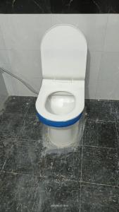 a bathroom with a white toilet in a stall at Hotel Mahadev in Sonprayag