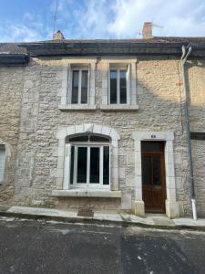 a stone building with a brown door and windows at Le gîte de Marie in Gramat