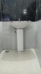 a white sink in a bathroom with a black wall at Hotel Mahadev in Sonprayag