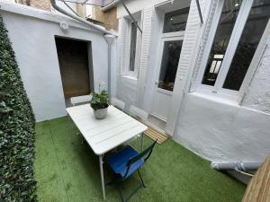a white table and a blue chair on a patio at Le gîte de Marie in Gramat