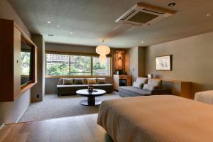 a bedroom with a bed and a couch and a table at HanaMOMIJI in Jozankei +67 photos