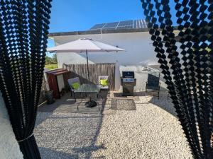 a patio with a table and an umbrella and chairs at Luxury Romantic Retreat with Hot Tub & Pool in Tábua +24 photos