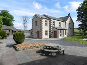 una casa con una mesa de picnic delante de ella en Bannerdale en Penrith