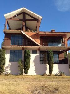 un grande edificio con cespugli di fronte di Hotel Lienzo Charro 1 a Huasca de Ocampo