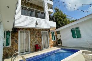 a house with a swimming pool in front of a house at Windy Ridge Hotel Tagaytay in Tagaytay