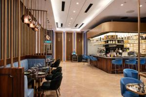 a restaurant with tables and chairs and a bar at STAR Residence KLCC - Dreamland Holiday Home in Kuala Lumpur