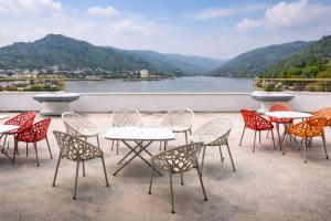 a group of tables and chairs on a balcony with a lake at Bridge Residency River View Hotel Near Bridge,201 in Muzaffarabad