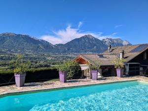 a house with a swimming pool with mountains in the background at Chalet romantique avec piscine in Monthion