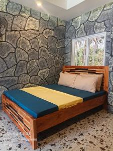 a bed in a room with a stone wall at Ocean View and Beach Access Rustic Stone House in Bolinao