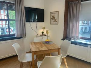 a dining room with a wooden table and white chairs at Altstadtappartment Plötze 13 Limburg in Limburg an der Lahn