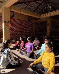a group of people sitting on the floor in meditation at Mazel Tov Stays, Tirthan Valley in Gushaini