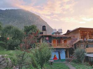 a house with a mountain in the background at Mazel Tov Stays, Tirthan Valley in Gushaini