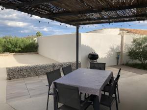 a table and chairs on a patio with a table and a grill at Le Boumian in Saintes-Maries-de-la-Mer