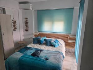 a bedroom with a large bed with blue pillows at Aura in Gerakini