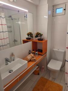 a bathroom with a sink and a toilet and a mirror at Aura in Gerakini +21 photos