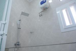 a bathroom with a shower and a window on the wall at Tanga New Apartments in Tanga