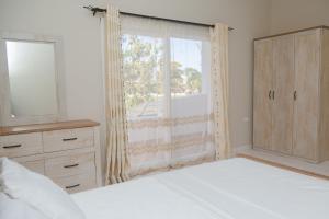 a bedroom with a bed and a large window at Tanga New Apartments in Tanga