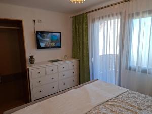a bedroom with a bed and a dresser and a window at Ferienhaus Weingarten Eisenberg in Vaskeresztes