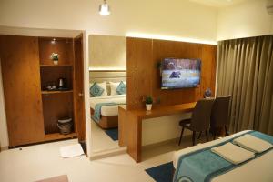 a hotel room with a bedroom with a bed and a desk at Hotel Sai Seeta Palace Newly Renovated in Shirdi