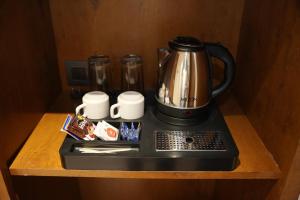 a coffee pot sitting on top of a counter at Hotel Sai Seeta Palace Newly Renovated in Shirdi +61 photos