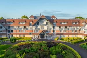 an exterior view of a large building with a courtyard at Renaissance Paris Hippodrome de St. Cloud Hotel in Rueil-Malmaison