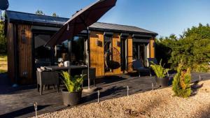 a tiny house with a table and chairs on a deck at Lutek in Olsztynek
