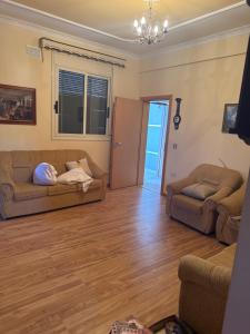 a living room with two couches and a wooden floor at Villa 24 maj cole vlore in Vlorë