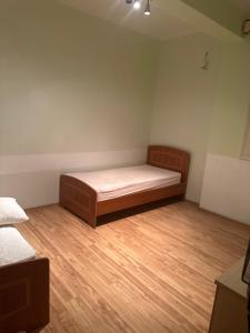 a bedroom with a bed and a wooden floor at Villa 24 maj cole vlore in Vlorë