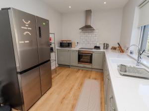 a kitchen with a stainless steel refrigerator and a sink at Amber Rose in Berwick-Upon-Tweed