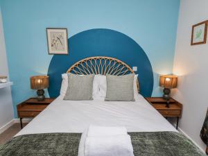 a bedroom with a large bed with a blue wall at Amber Rose in Berwick-Upon-Tweed