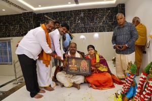 a group of people standing around a man holding a picture at PNR CONVENTION hall in Jāmb