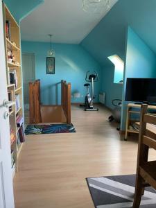 a living room with blue walls and a wooden floor at La Suite Dorée à Amaryllis in La Guierche