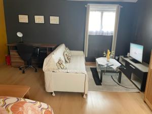 a living room with a chair and a desk with a computer at La Suite Dorée à Amaryllis in La Guierche