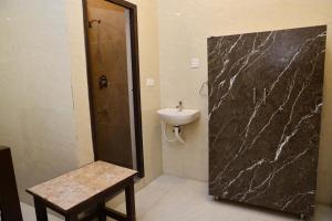 a bathroom with a sink and a shower and a toilet at PNR CONVENTION hall in Jāmb
