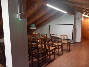 a room with a table and chairs and a chalkboard at The Green Owl in Antey-Saint-André