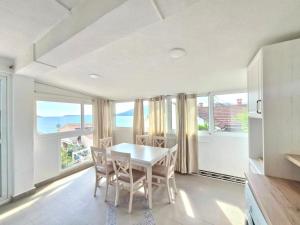a dining room with a table and chairs and windows at Apartments Miljevic in Herceg-Novi