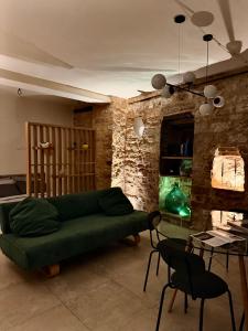 a living room with a green couch and a table at Loft in Love in Spello