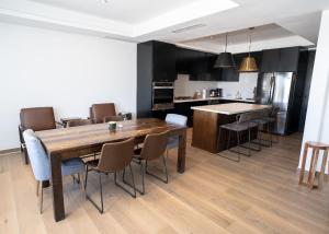 a kitchen and dining room with a wooden table and chairs at Casa Puerto Azul in San Carlos