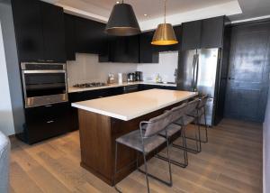 a kitchen with black cabinets and a island with bar stools at Casa Puerto Azul in San Carlos