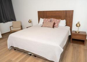 a bedroom with a large white bed and a chair at Casa Puerto Azul in San Carlos