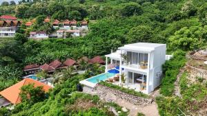 an aerial view of a house with a swimming pool at NEW! 3BR Ocean View, Infinity Pool, Villa Helios in Sampalan