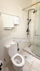 a bathroom with a toilet and a shower at AA Luxury Apartments in Abuja