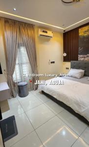 a bedroom with a large bed and a window at AA Luxury Apartments in Abuja