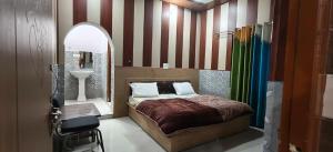 a bedroom with a bed and a sink and a mirror at Omji Niwas - Kalindi in Kharsālī