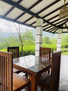 a dining table and chairs under a pergola at Rainforest Mount Villa in Nelluwa