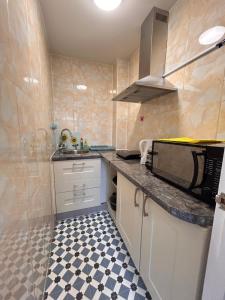 a small kitchen with a sink and a microwave at Comfortable en-suite one bed room studio in Oxford