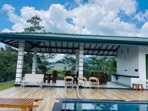 a pavilion with a table and chairs next to a pool at Rainforest Mount Villa in Nelluwa